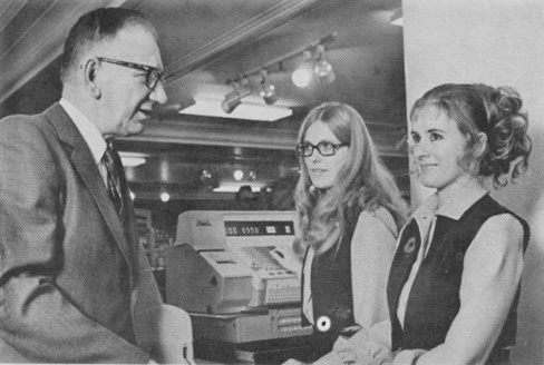 Photo en noir et blanc de l’ouverture d’un magasin La Baie vers janvier 1971. Le maire de Winnipeg Stephen Juba s’entretient avec les commis de magasin Elizabeth Lukawski et Peggy Toonstra.