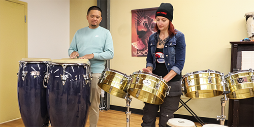 Life’s Journey employees play congas and timbales from MBLL’s asset donation program.