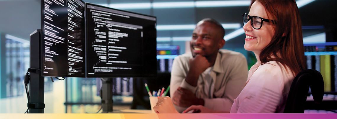 two employees looking at code on a screen