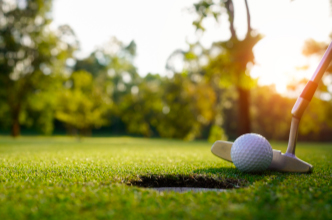 Close up of golf ball being putted into a hole